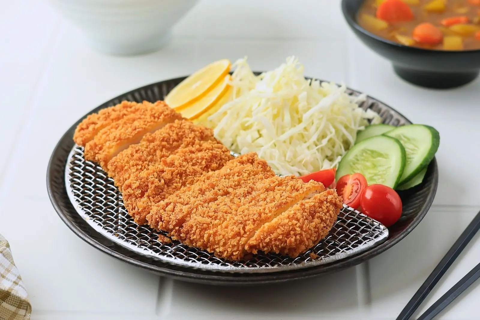 Fried tonkatsu served with cabbage, cucumber and lemon at Umai, a Asian Fusion Restaurant in Keizer